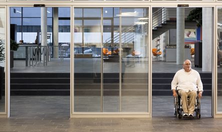 A disable person passing through an automatic door seamlessly. 